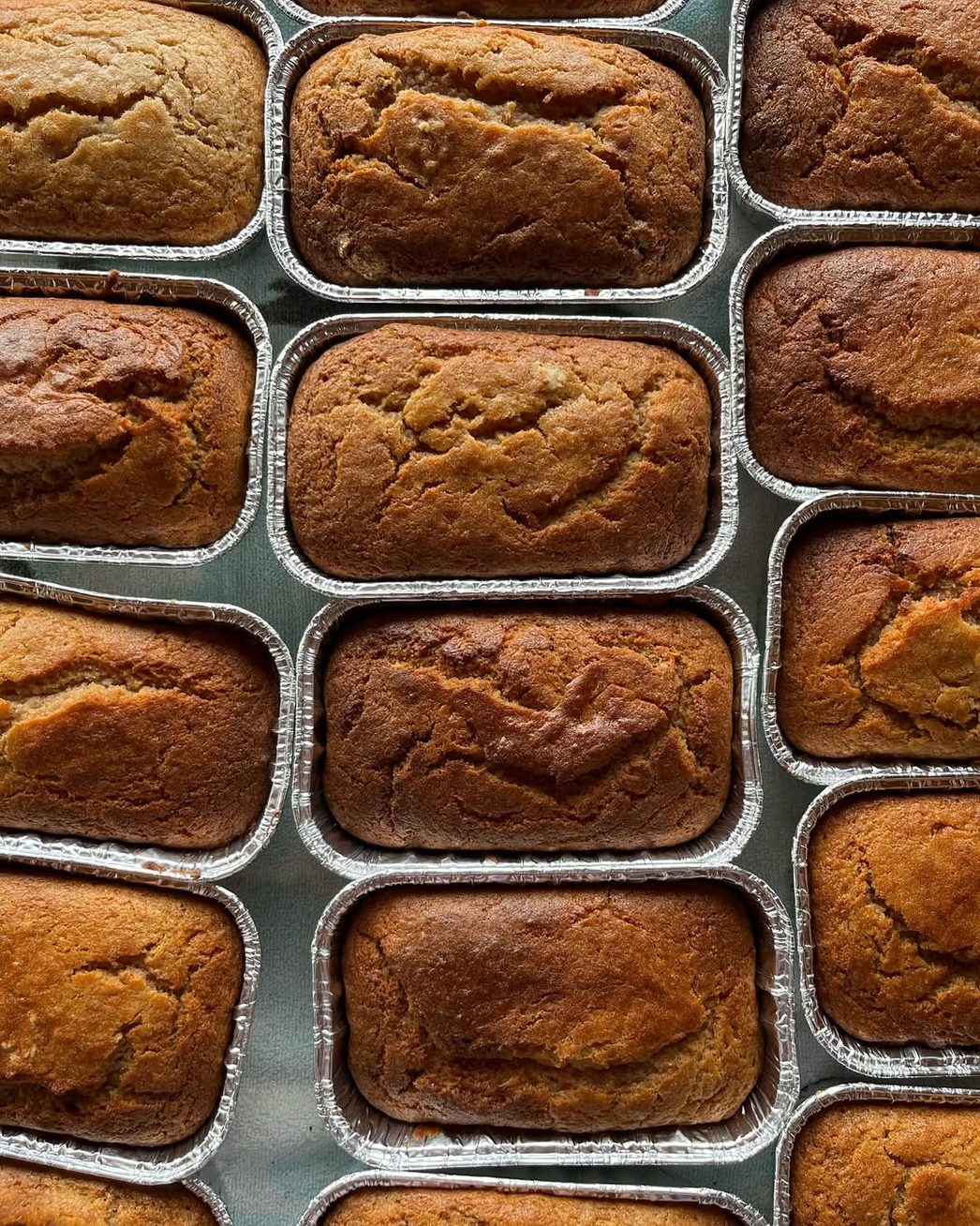 Banana bread loaves in foil pans, seen from above.