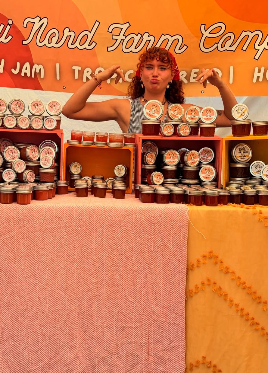 The market booth, with the Maui Nord Farm Company banner and crates of jars.