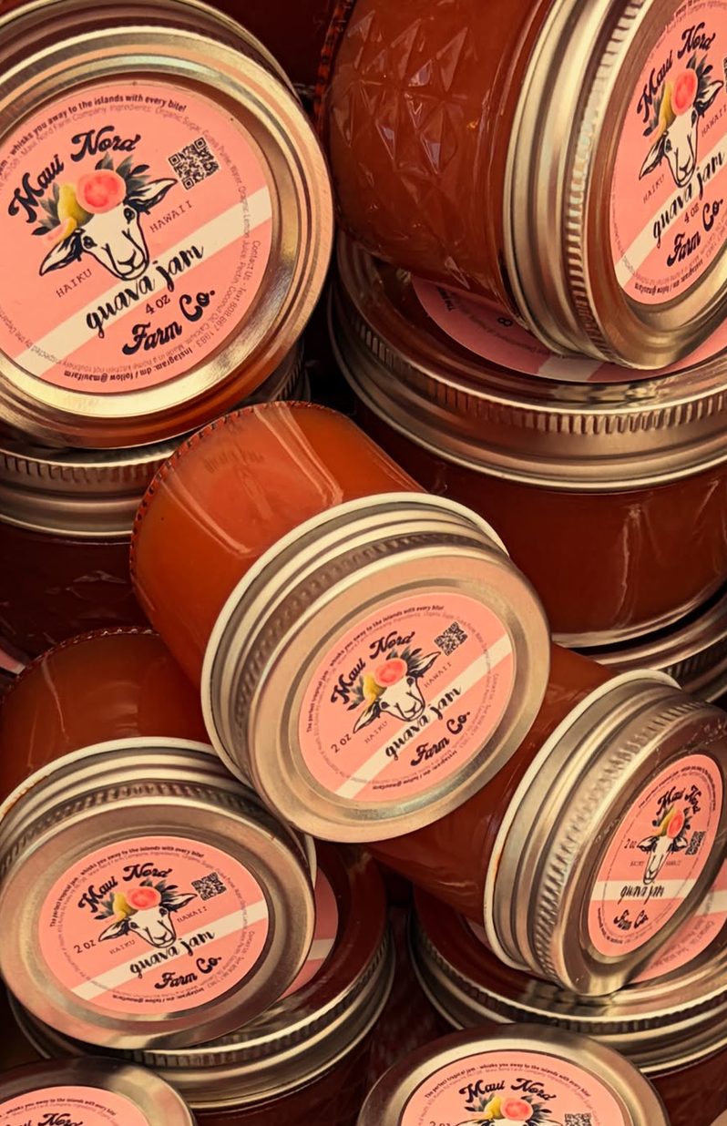 Guava jam jars in two and four ounce sizes, stacked at angles.