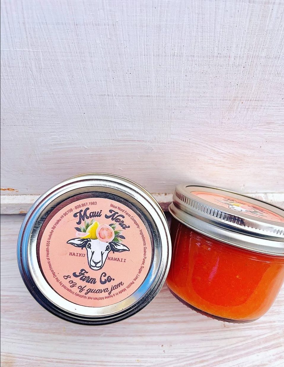 Two jars of guava jam, one on its side showing the sheep on the lid.
