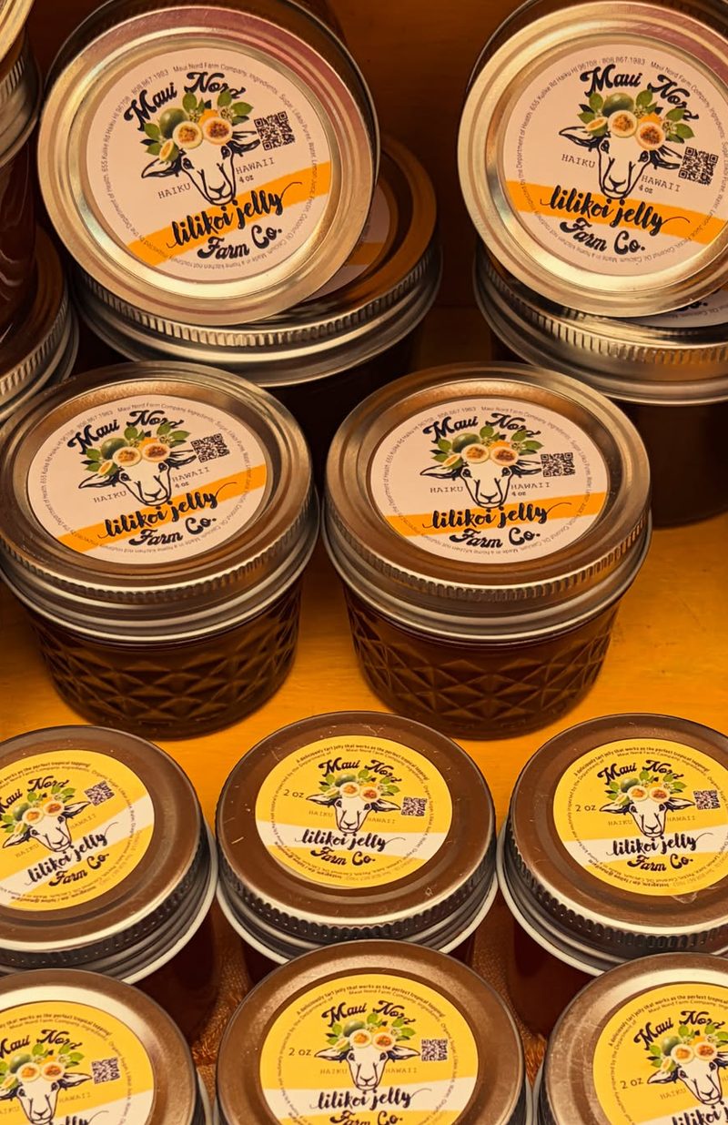 Lilikoi jelly jars in four and two ounce sizes on a shelf.